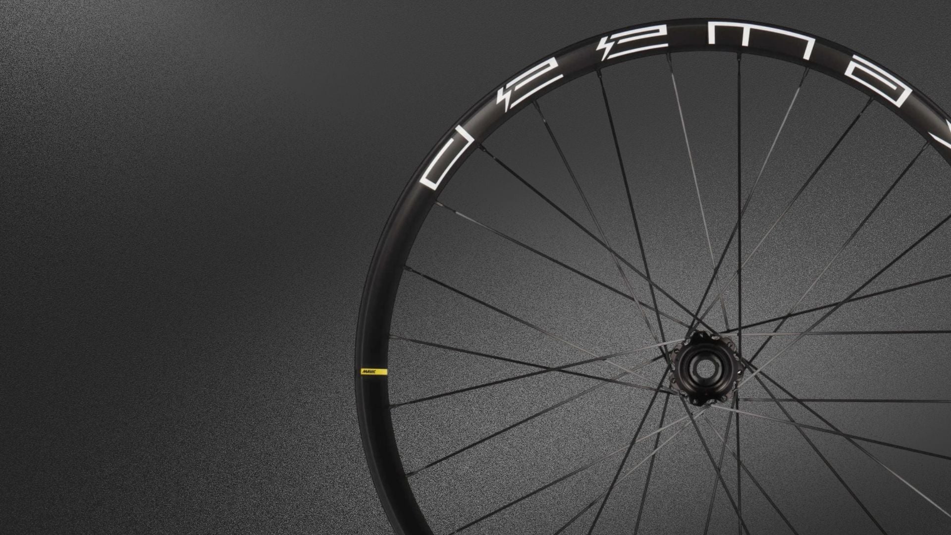 Minimalistische Nahaufnahme eines schwarzen Fahrradlaufrads vor dunklem Hintergrund